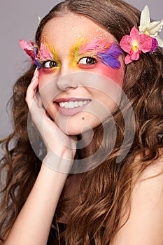 Female with hand near face and fashion feather eyelashes make-up