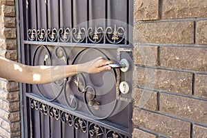 A female hand opens the front street door