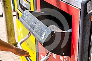 Female hand opens the lid of street rubbish bin.