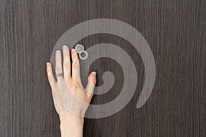 Female hand opens the metal door peephole cover