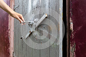 female hand opens the old door leading to the basement