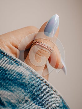Female hand with pastel blue nail and with beautiful stylish ring on finger. Close up photo. Nail polish