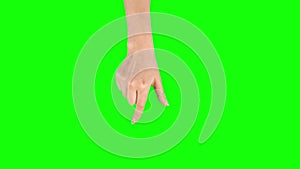 Female hand is performing spread and single tap at tablet screen gesture on green screen. Close up