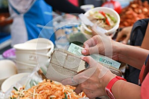 Female hand picking up money to pay for goods