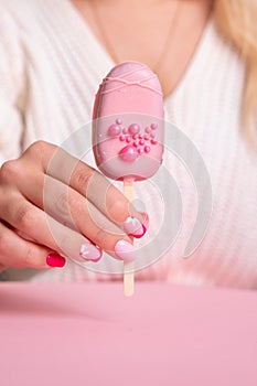 Female hand with pink manicure nails, hearts design