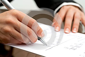 Female hand pointing on accounting document.