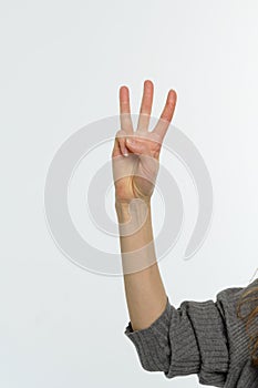 Female hand pointing up with finger number three