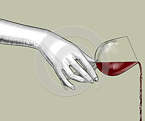 Female hand pours wine from a glass