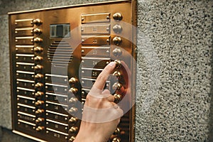 Hand presses the intercom button