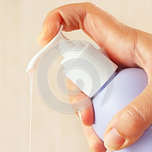 Female hand presses the liquid soap dispenser