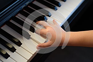 A female hand presses the piano keys. Early musical development in young children