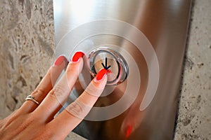 Female hand pressing elevator button