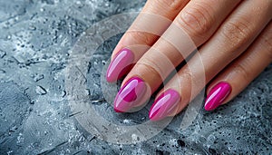 Female hand with purple manicure on gray background, top view.