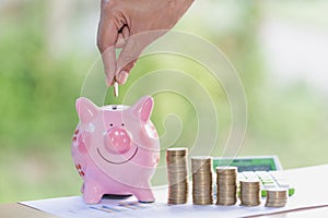 Female hand putting a coin into piggy bank , for invest money, I