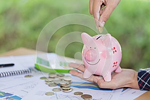 Female hand putting a coin into piggy bank , for invest money, I