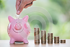 Female hand putting a coin into piggy bank , for invest money, I