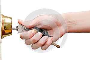 Female hand putting house key into front door lock isolated