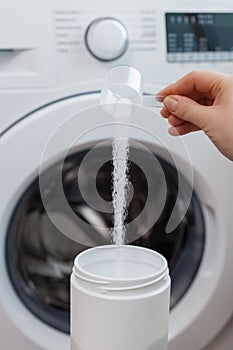 Female hand putting washing powder. Washing linen and clothes idea. Correct use of the washing machine concept. New