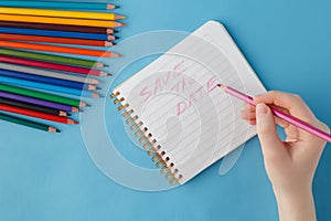 Female hand ready to writhe phrase in notebook