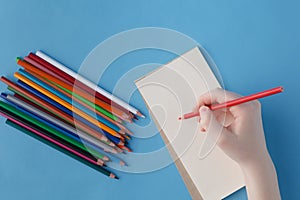 Female hand ready to writhe phrase in notebook