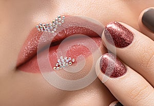 Female hand with red nail design. Brown nail polish manicured hand. Pink female lips design close up