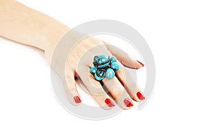 Female hand with red nails with turquoise ring