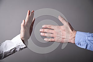 Female hand refusing male hand to shake