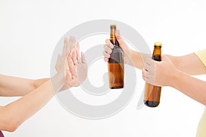 Female hand reject a bottle of beer isolated on white background.anti alcohol concept. Copy space