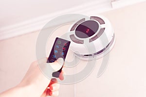 Female hand by remote control turning on recuperator for fresh indoor air quality photo