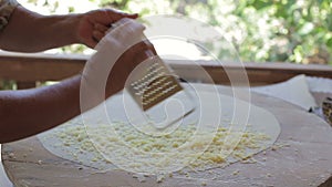 Female hand rub cheese on a grater