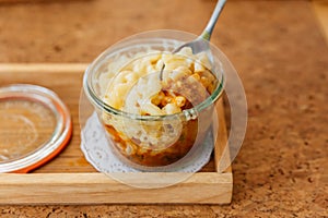 Female hand is scooping Macaroni Cheese Baked with meat sauce in glass bowl