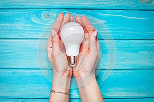 Female hand selected led lamp on blue wood background