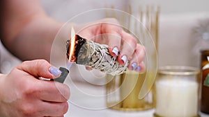 Female hand sets fire to incense on a copper bowl. Aroma therapy, to relax after a hard day. Smells for concentration