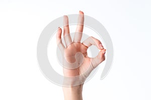 Female hand showing the gesture from contacting each other index finger and thumb is isolated on a white background