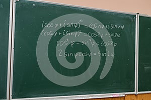 Female hand showing math formula in chalkboard. Back to school