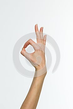 Female hand showing the ok gesture isolated on a white background