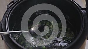 Female hand shuffles peas in water close-up