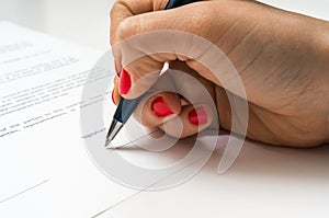 Female hand signing contract to conclude a deal