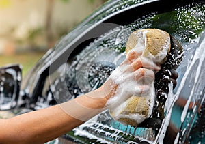 Female hand with sponge for washing windows