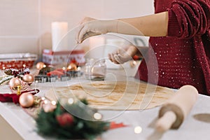 Female hand with sprinkling cinnamon on rollout dough