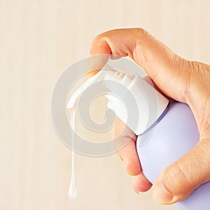 Female hand squeezing liquid soap from bottle