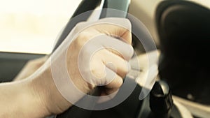 Female hand on steering wheel.