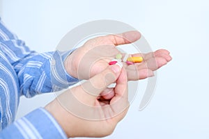 female hand stretches on palm pills, medicinal capsules, vitamins, close-up drugs in female palm on blurred light background,