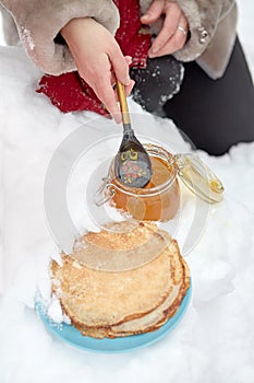 Female hand takes honey with wooden spoon from