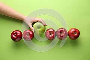 Female hand with tasty apples on color background. Concept of uniqueness