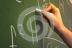 Female Hand Teacher Writing on Green Chalkboard Professor University White Chalk College Education Lesson Math Number Pi