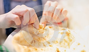 Female hand tearing of a piece of nan bread and preparing to eat with the egyptian food, The culture food concept