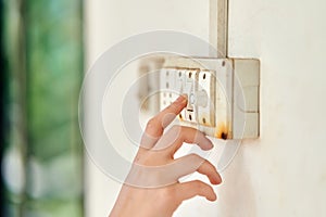 Female hand, to turn off the light, switch, side view