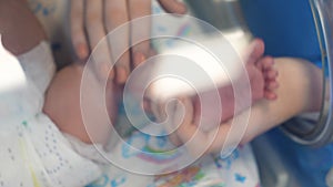 Female hand is touching a leg of a new-born child