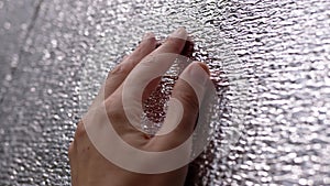 Female Hand touching the Rough Surface of a Heat Reflector Foil. Close-up. 4K